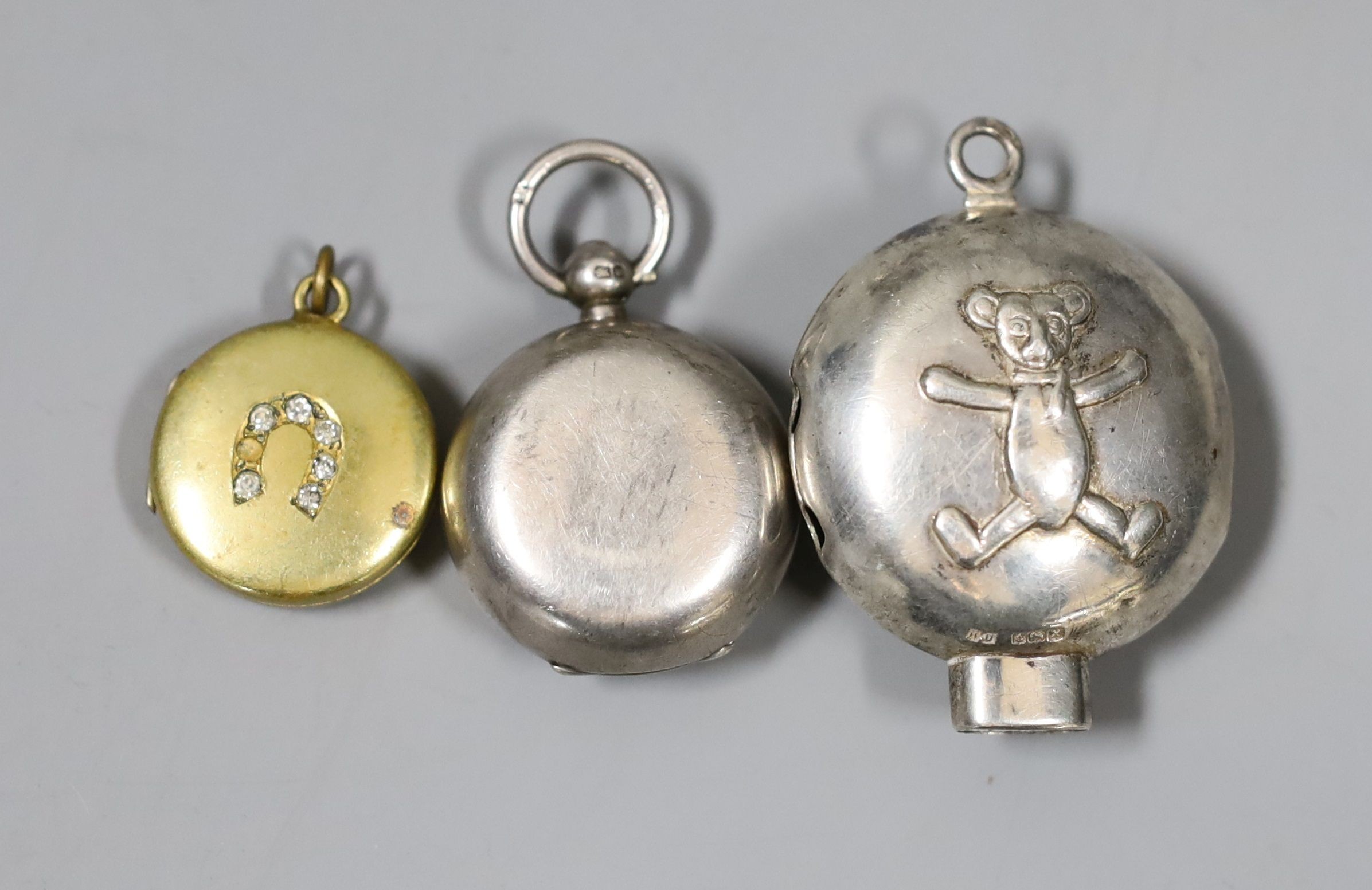 A modern Irish silver christening mug, Royal Irish Silver Co. Dublin, 1974, retailed by Asprey, London, 7cm, a late Victorian silver sovereign case, a gilt metal locket, part of a child's silver rattle and a polychrome e